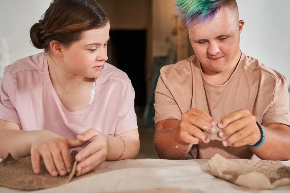 Two disabled friends with down syndrome in arts and craft class